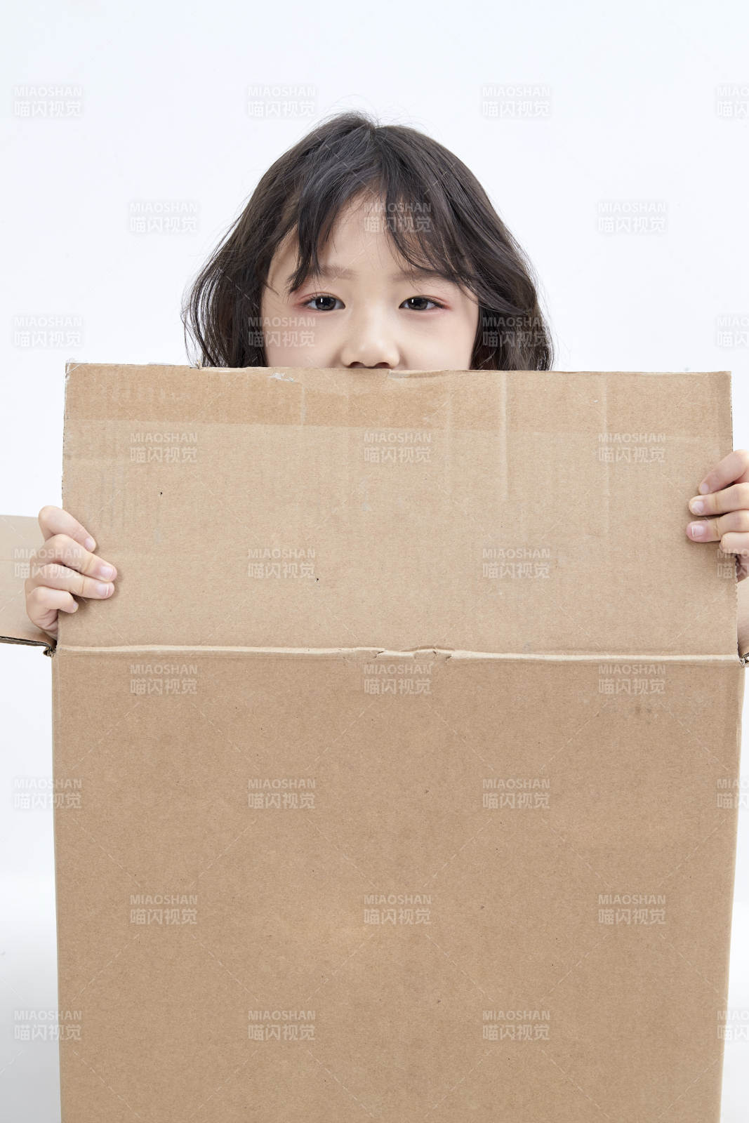 躲在纸箱中玩耍的调皮可爱亚洲小女孩儿童图片
