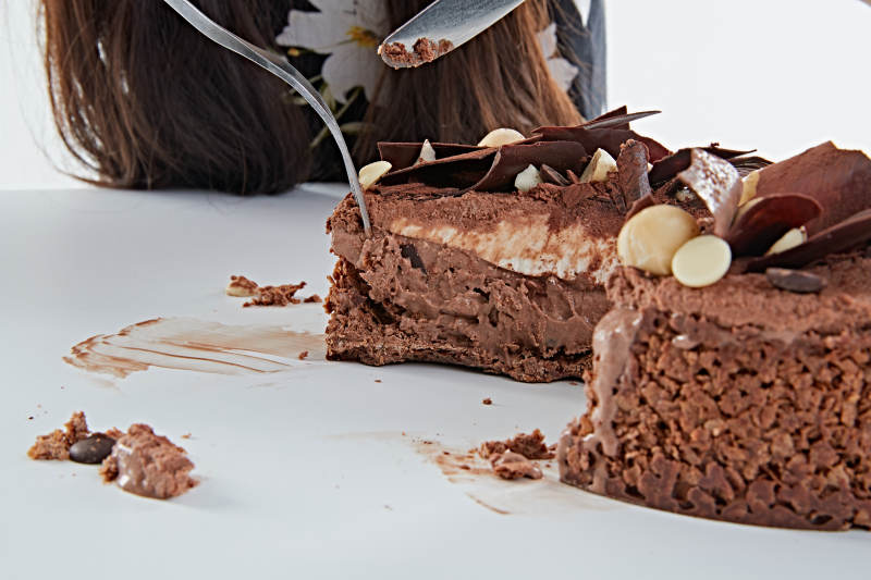 喝红酒品尝蛋糕的年轻女性图片