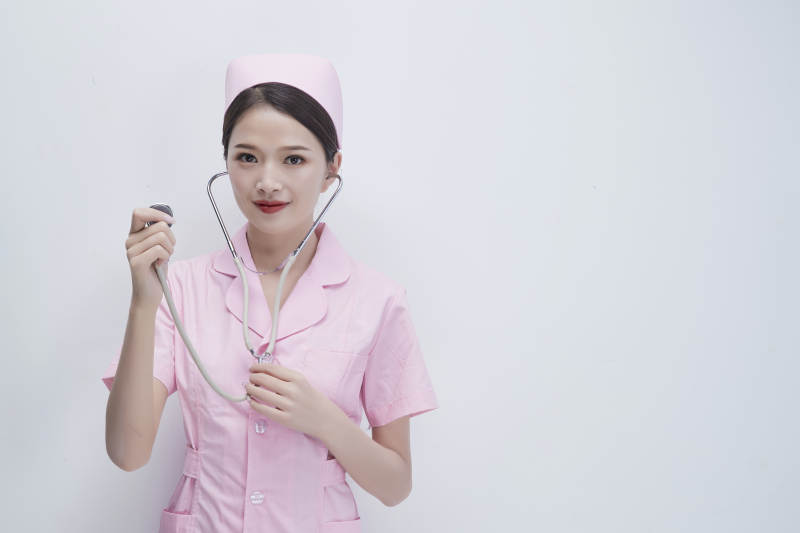 身穿粉色护士服佩戴听诊器的女性医护人员图片