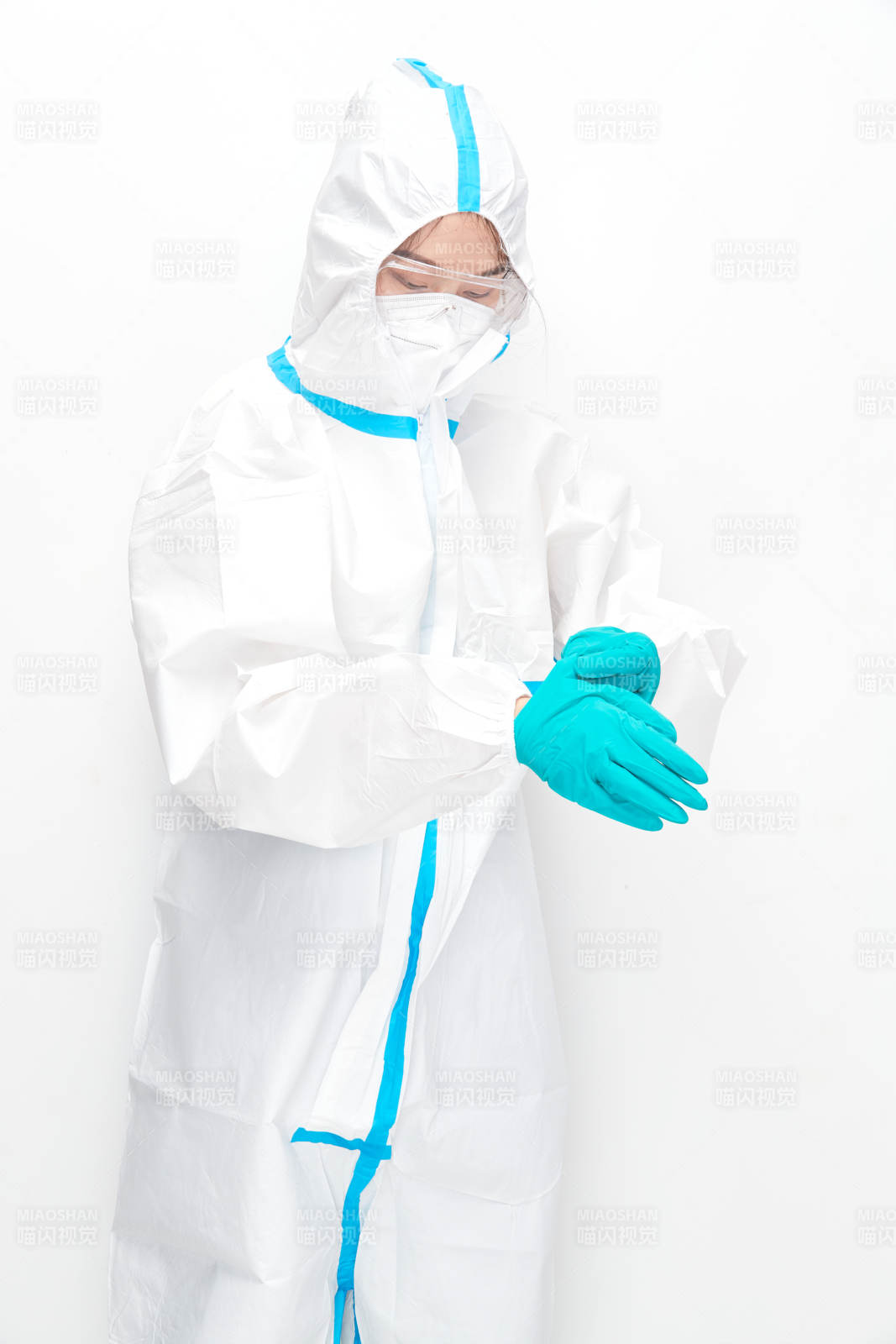 穿白色防护服佩戴护目镜口罩的女性医疗人员图片