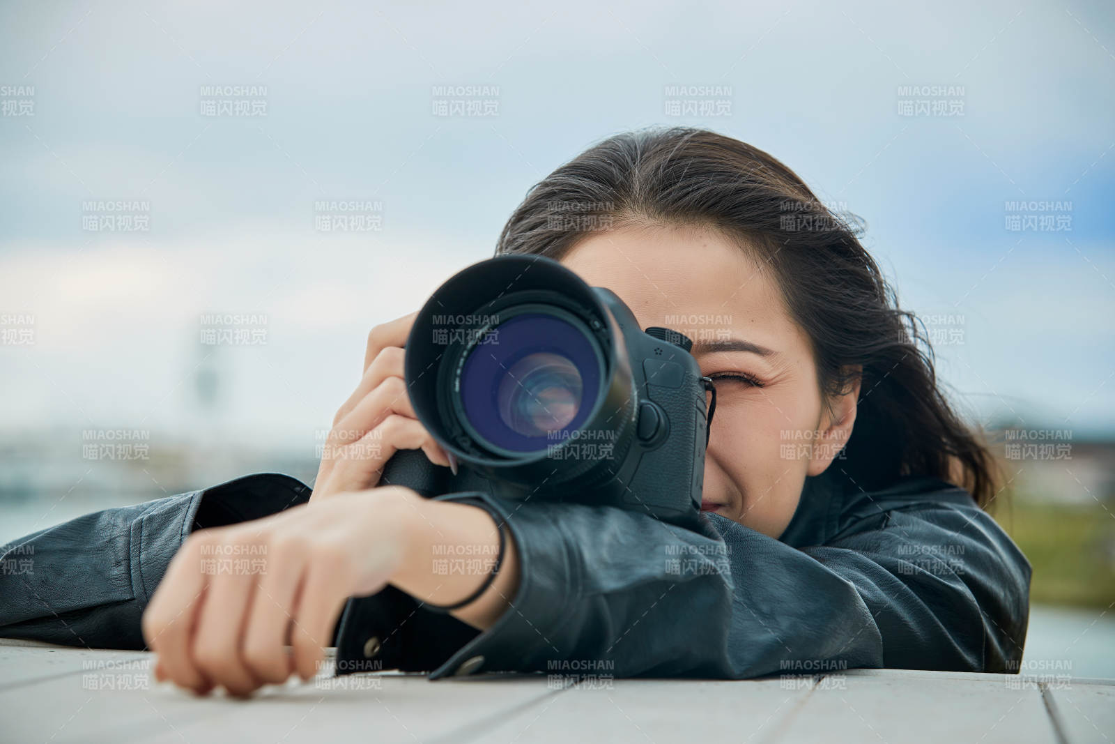 户外湖畔进行拍摄的亚洲青年女性摄影师图片