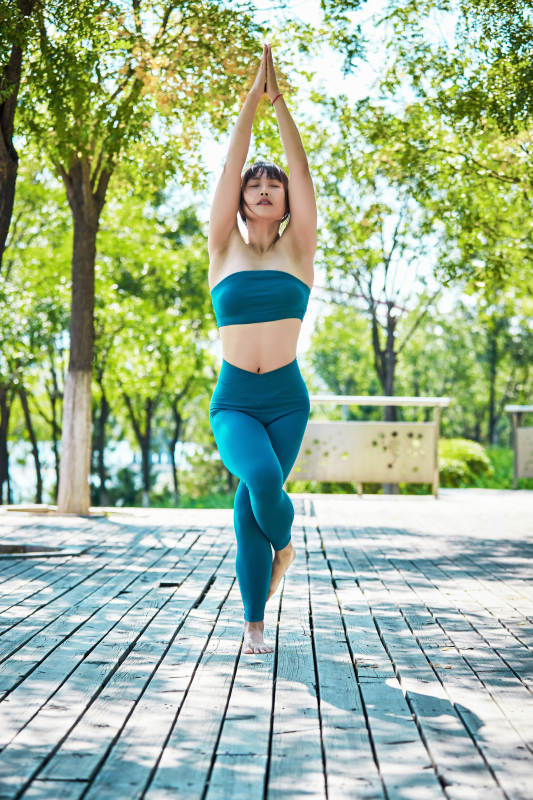 湖畔公园做瑜伽动作的亚洲年轻女性图片