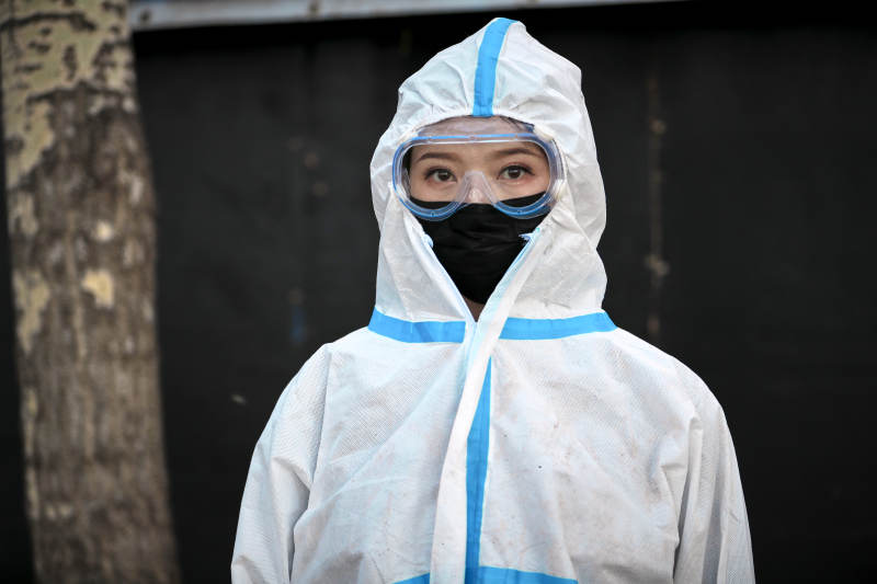 穿白色防护服佩戴护目镜口罩的女性防护人员图片