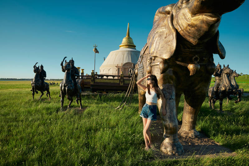草原湿地公园游玩拍照的亚洲少女图片