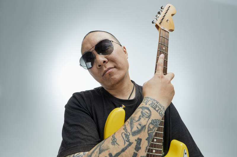 手持电吉他展示演奏的亚洲男性摇滚乐手人像图片