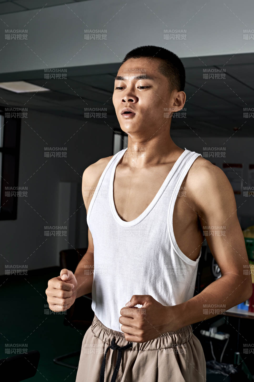 在室内用跑步机进行锻炼的亚洲健身男士形象图片