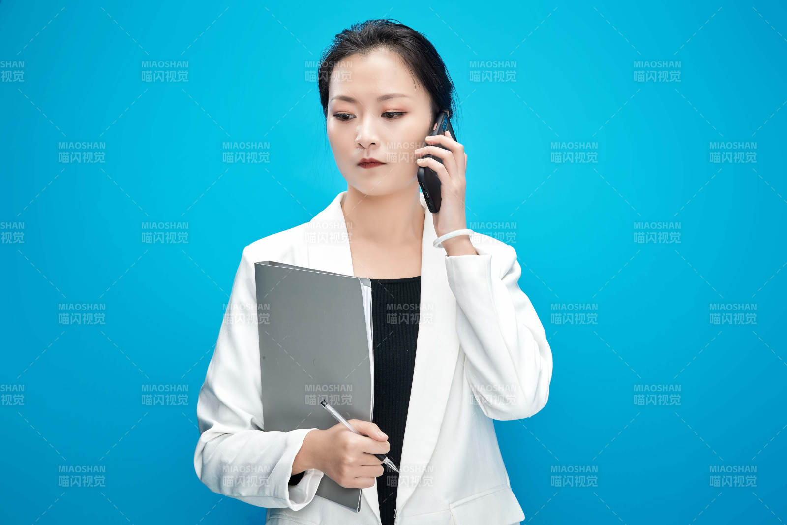 身穿西服拿着手机与文件夹的亚洲商务女士图片