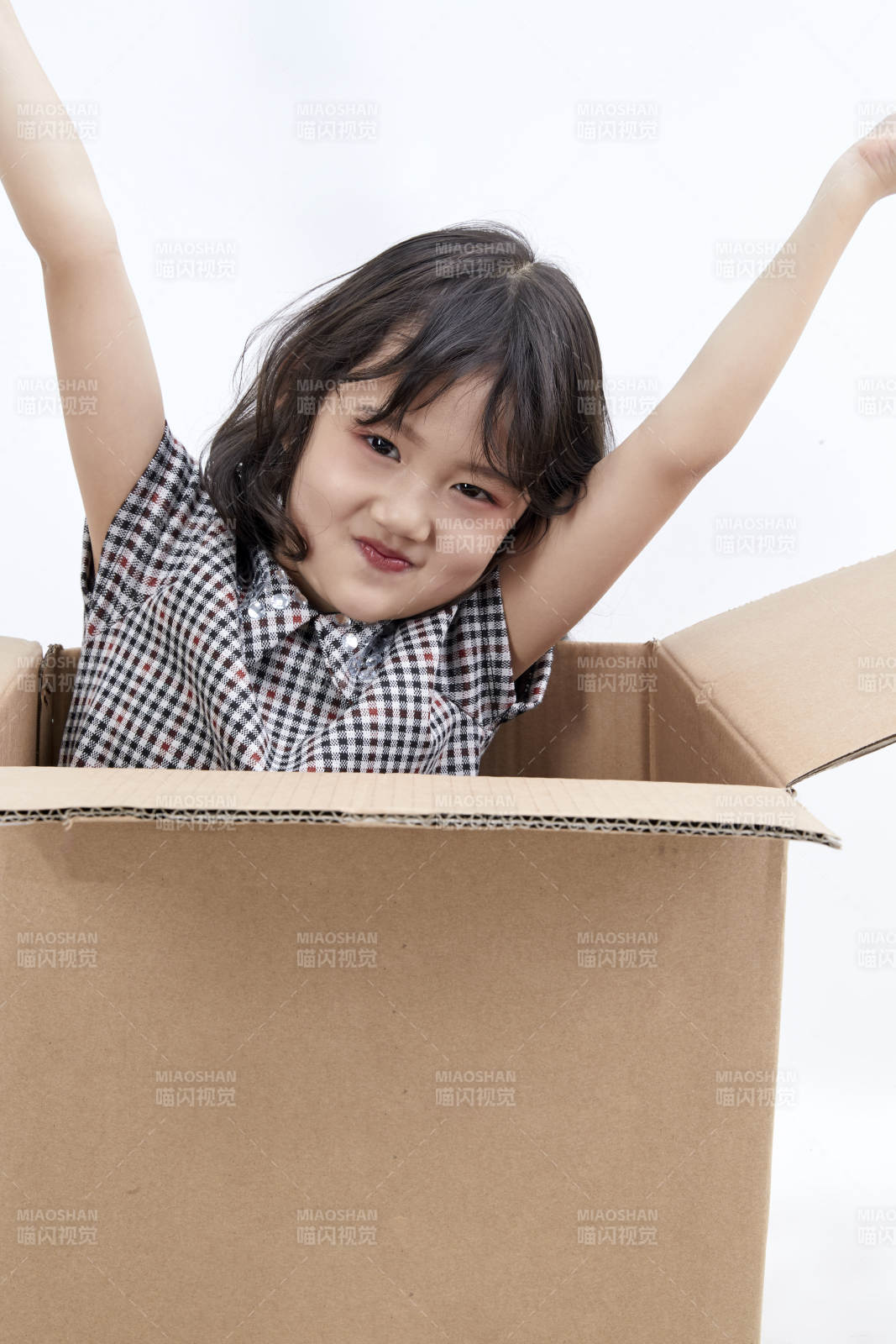 躲在纸箱中玩耍的调皮可爱亚洲小女孩儿童图片