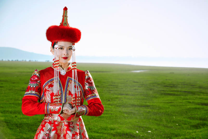 草原上穿着蒙古族传统服饰的亚洲年轻美少女图片