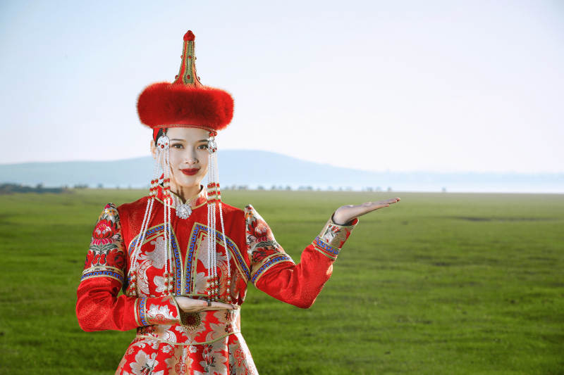 草原上穿着蒙古族传统服饰的亚洲年轻美少女图片