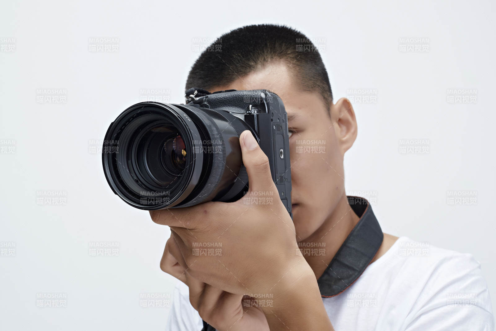 白色背景下手持照相机的亚洲男性摄影师图片
