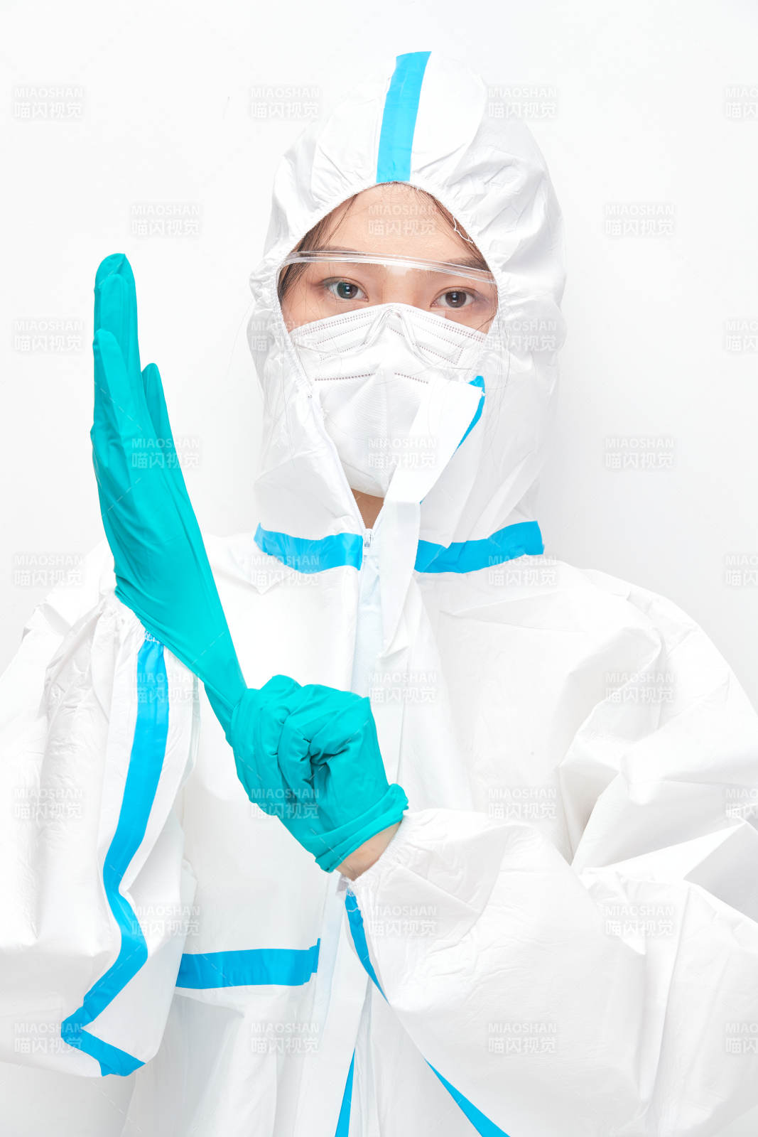 穿白色防护服佩戴护目镜口罩的女性医疗人员图片