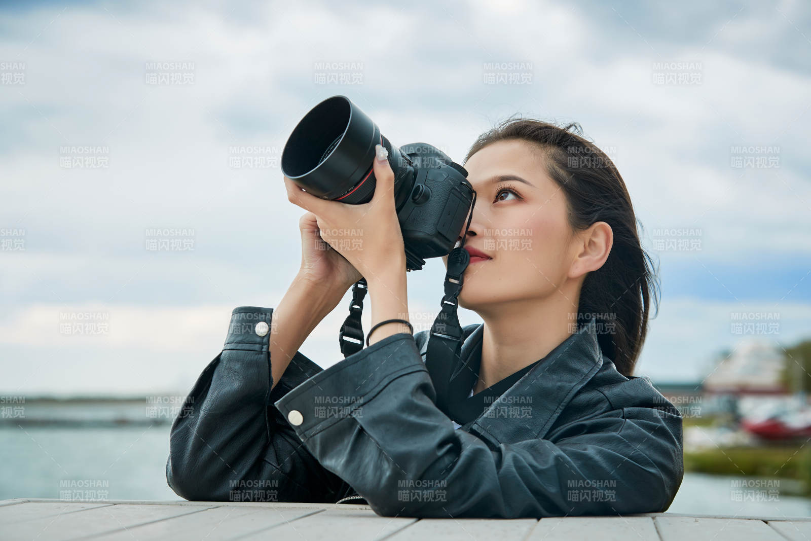 户外湖畔进行拍摄的亚洲青年女性摄影师图片