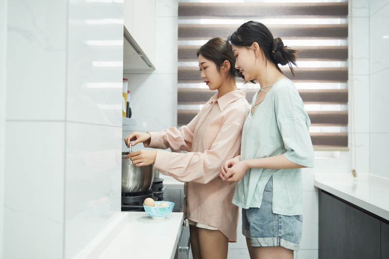 在厨房烹饪美食的亚洲闺蜜少女图片