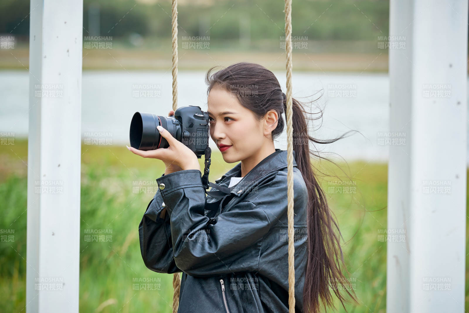 户外湖畔进行拍摄的亚洲青年女性摄影师图片
