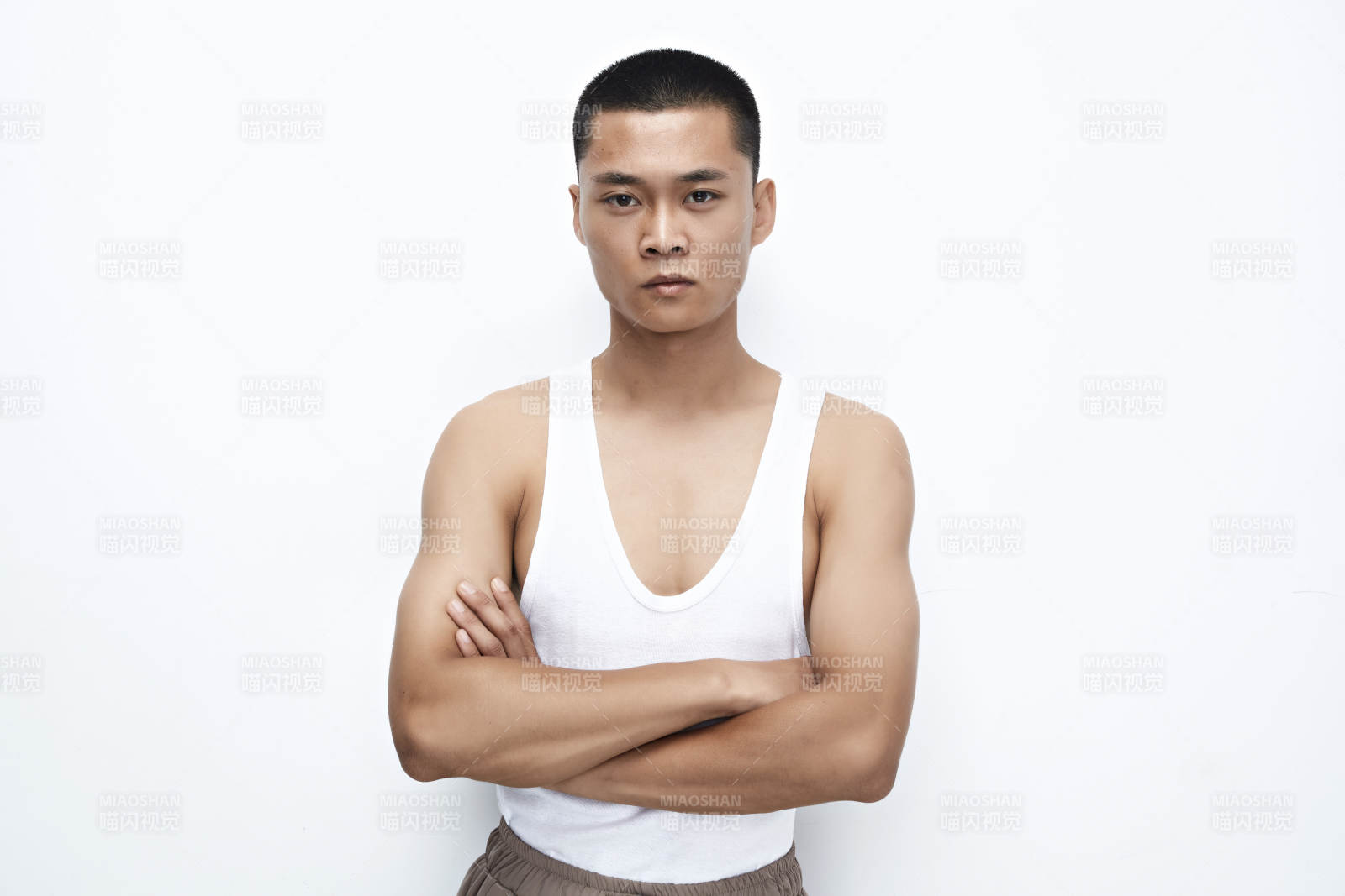 白色背景下展示健身预备拉伸动作的亚洲男性图片