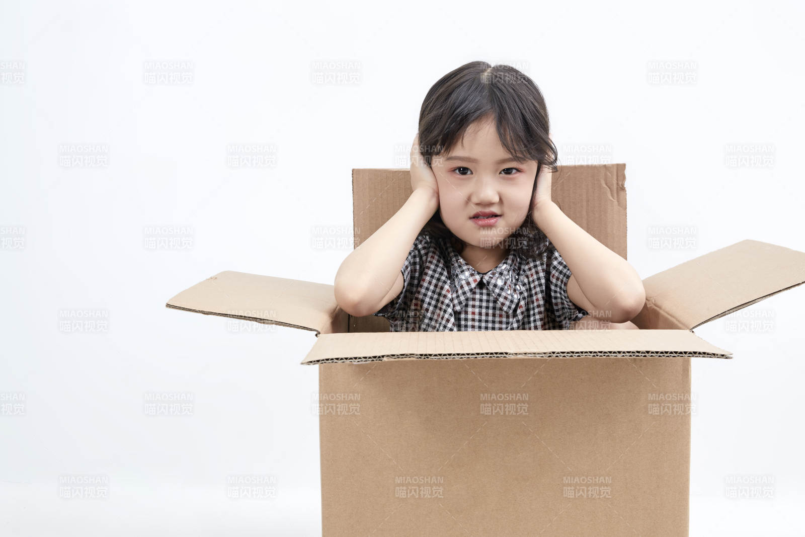 躲在纸箱中玩耍的调皮可爱亚洲小女孩儿童图片