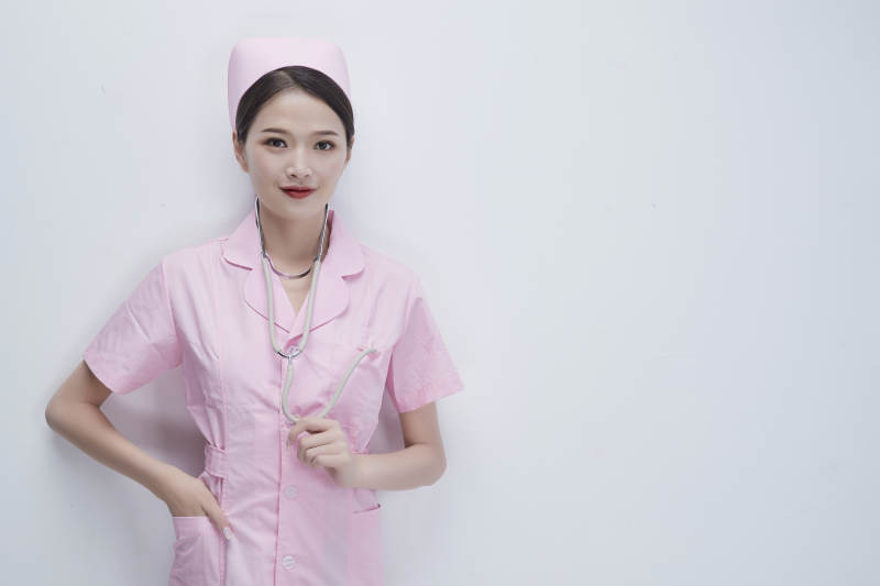 身穿粉色护士服佩戴听诊器的女性医护人员图片