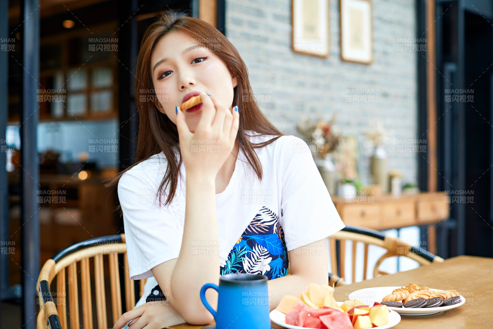 坐在咖啡图书馆吃东西的可爱少女图片