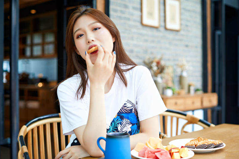 坐在咖啡图书馆吃东西的可爱少女图片