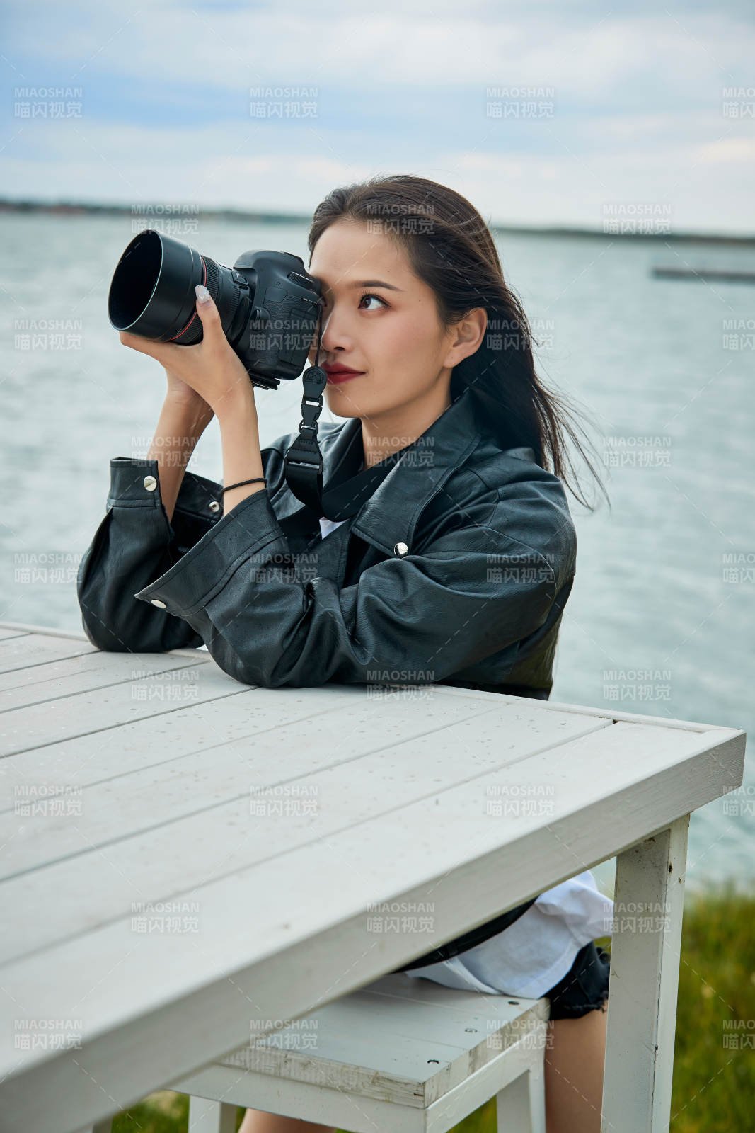 户外湖畔进行拍摄的亚洲青年女性摄影师图片