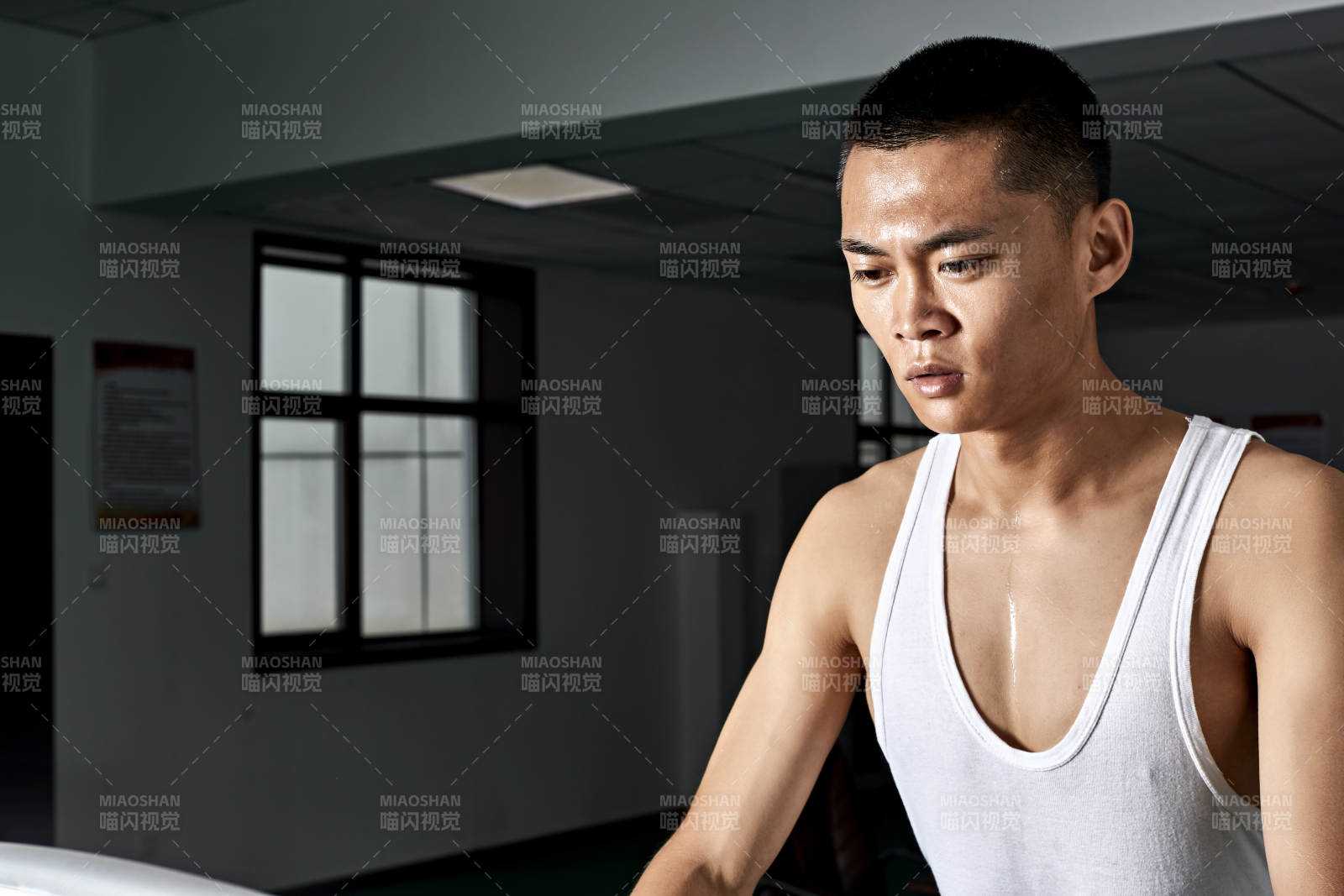 在室内用跑步机进行锻炼的亚洲健身男士形象图片