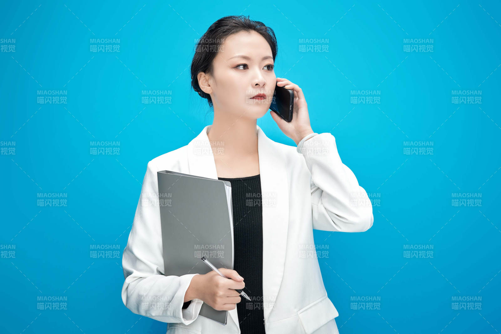 身穿西服拿着手机与文件夹的亚洲商务女士图片