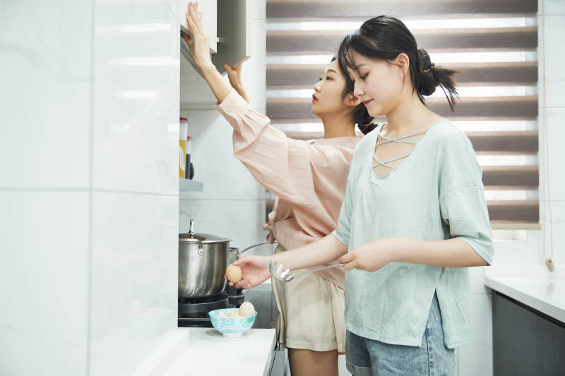 在厨房烹饪美食的亚洲闺蜜少女图片