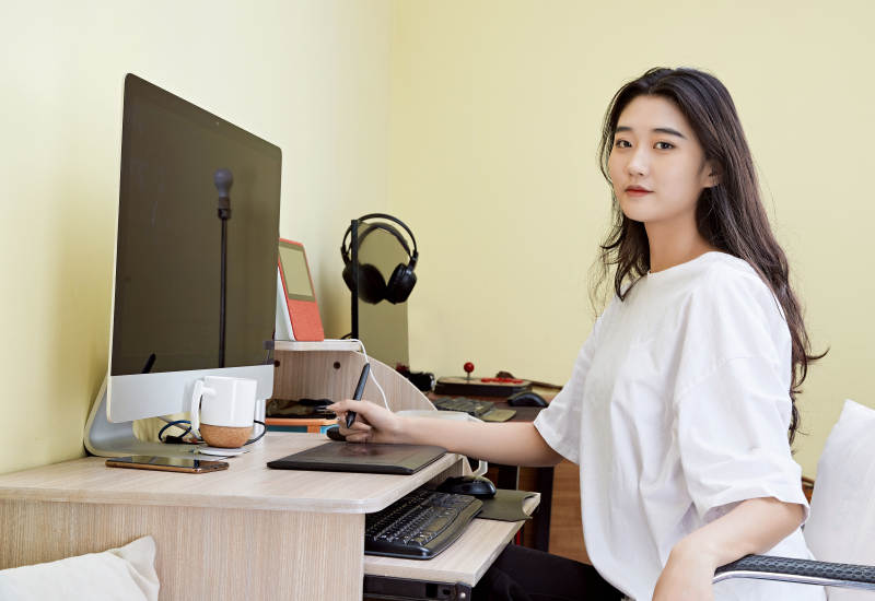 居家在电脑前创作插画的年轻美女图片