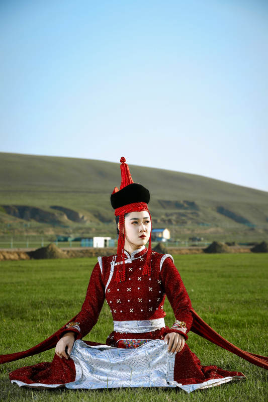 草原上穿着蒙古族传统服饰的亚洲年轻美少女图片