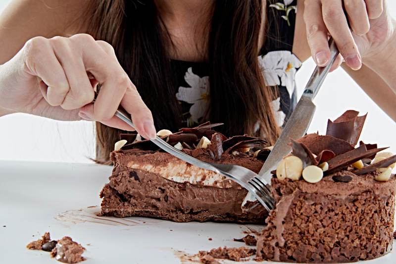 喝红酒品尝蛋糕的年轻女性图片