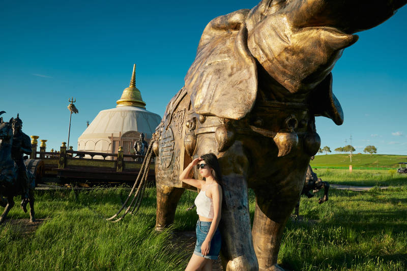 草原湿地公园游玩拍照的亚洲少女图片