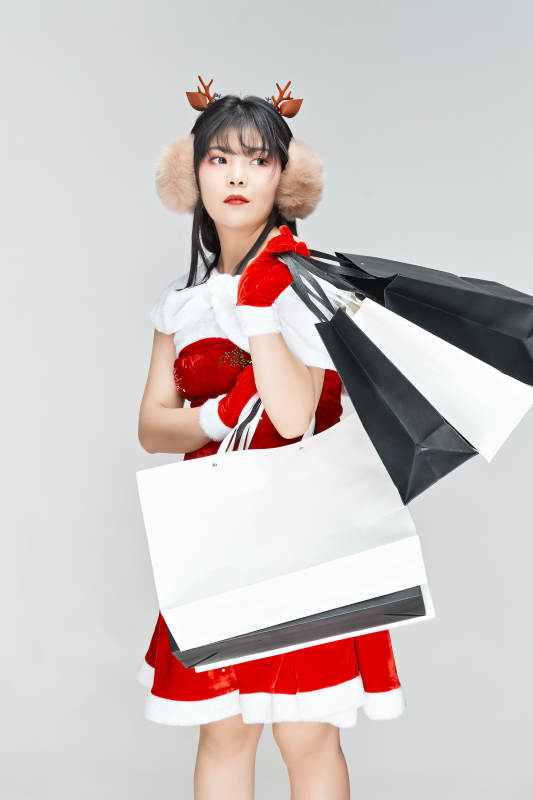 身穿圣诞服饰手提购物袋性感可爱的圣诞女郎图片