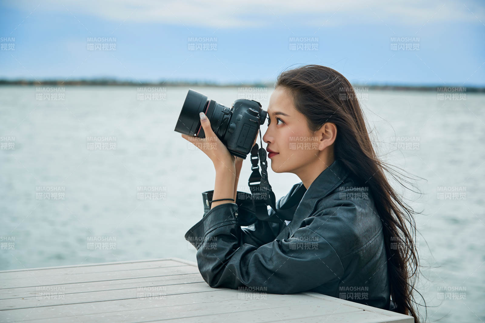户外湖畔进行拍摄的亚洲青年女性摄影师图片