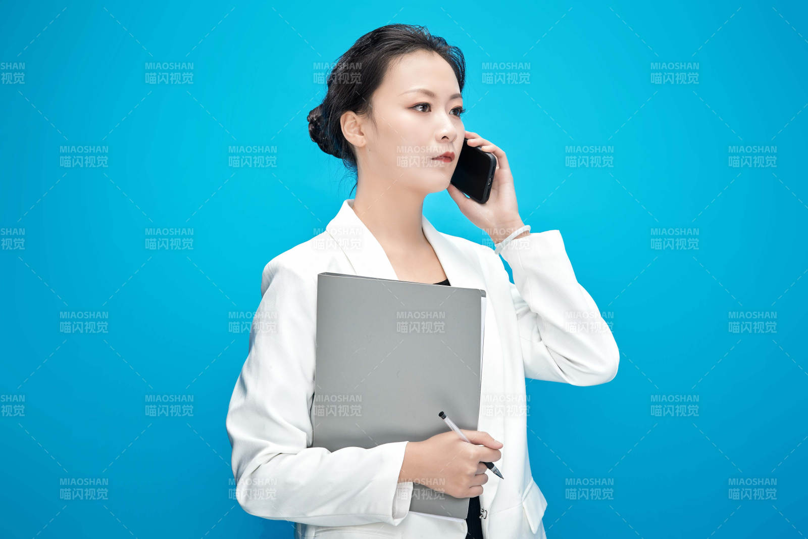 身穿西服拿着手机与文件夹的亚洲商务女士图片