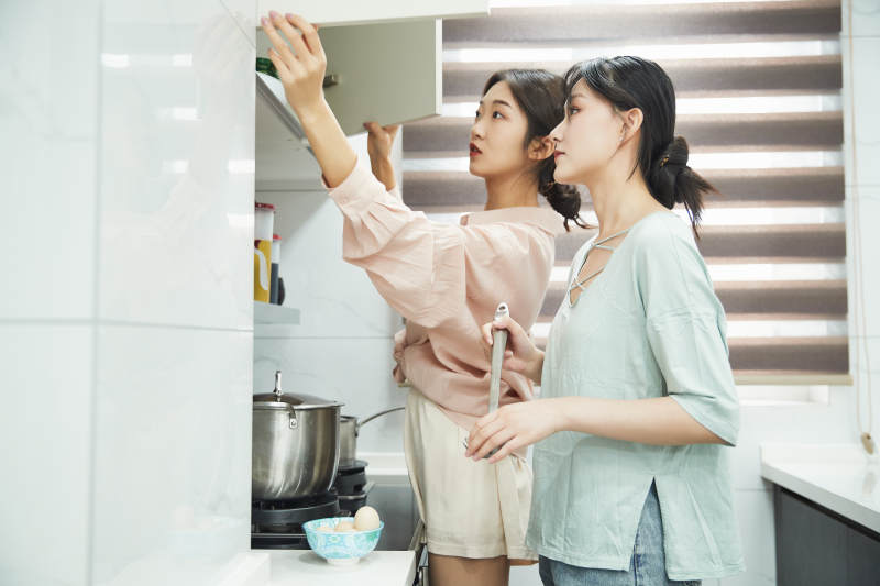 在厨房烹饪美食的亚洲闺蜜少女图片