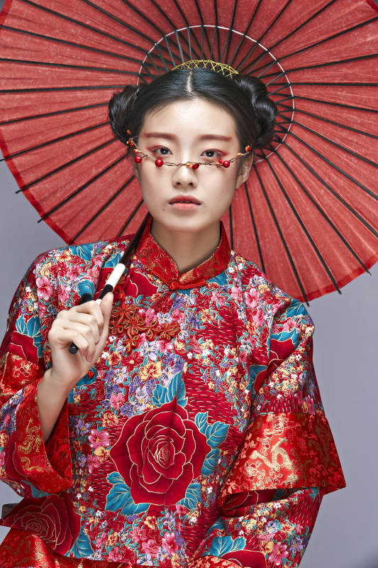 身穿中国秀禾服手撑油纸伞的亚洲女性模特图片