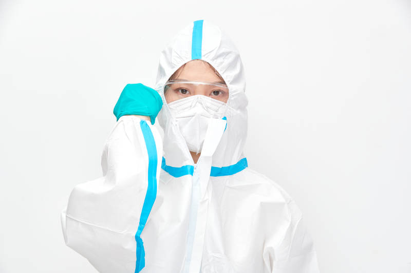 穿白色防护服佩戴护目镜口罩的女性医疗人员图片