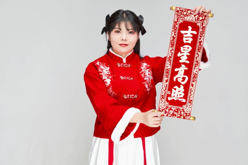 手持春联身穿喜庆汉服的可爱少女图片