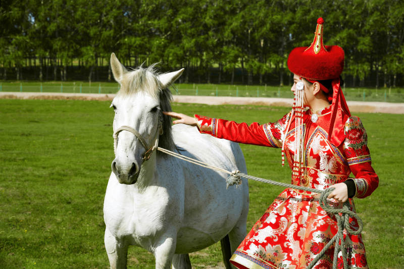 草原上穿着蒙古族传统服饰的亚洲年轻美少女图片