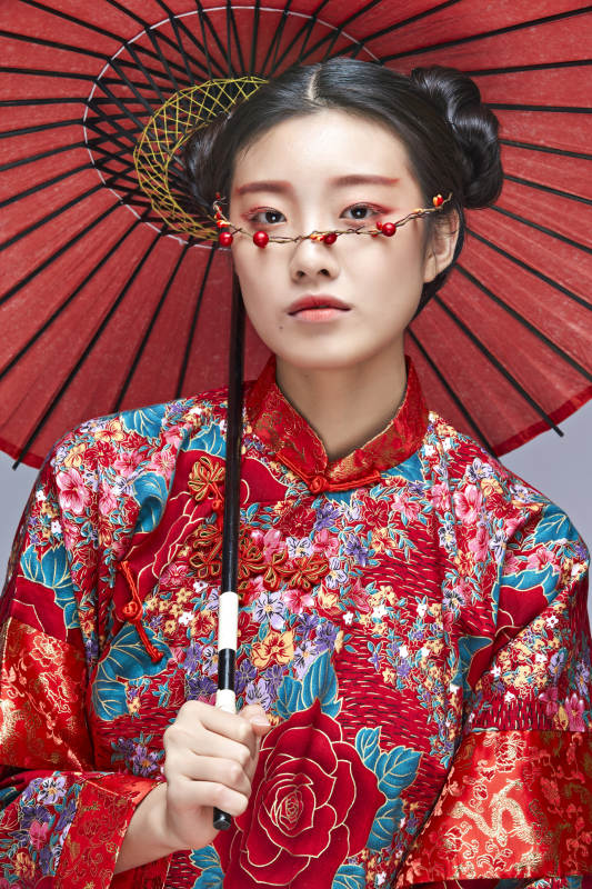 身穿中国秀禾服手撑油纸伞的亚洲女性模特图片