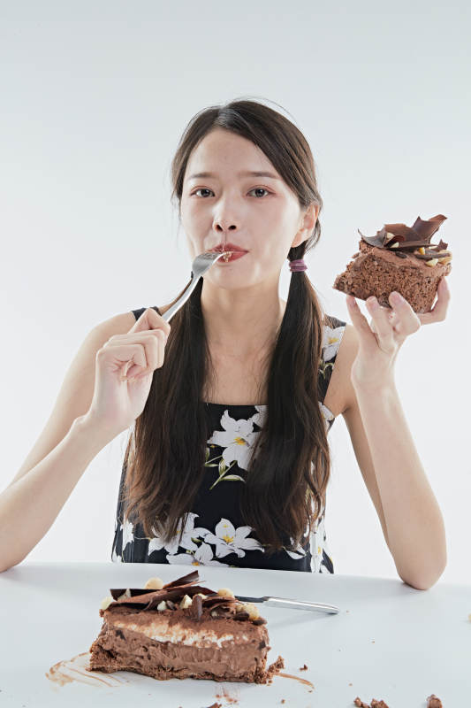 喝红酒品尝蛋糕的年轻女性图片