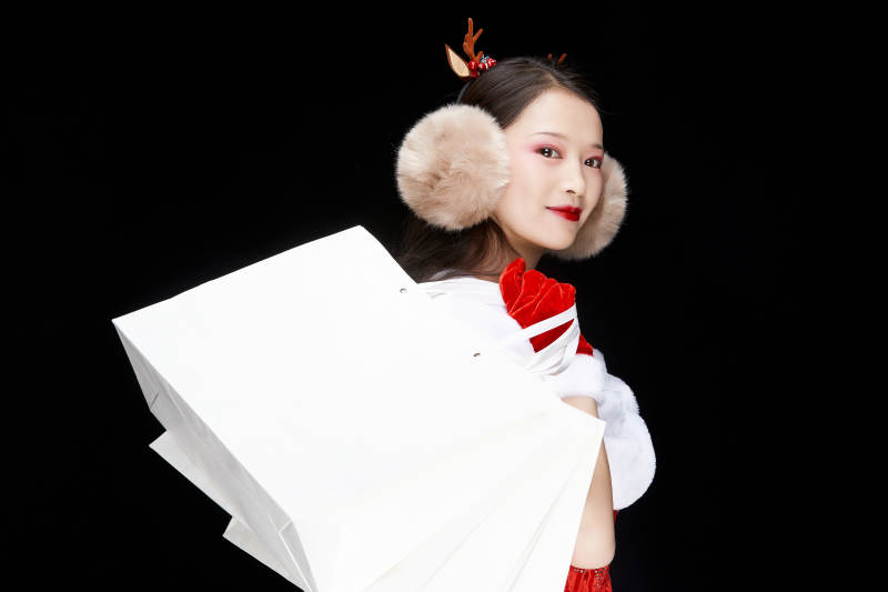 身穿圣诞服饰手提购物袋性感可爱的圣诞女郎图片