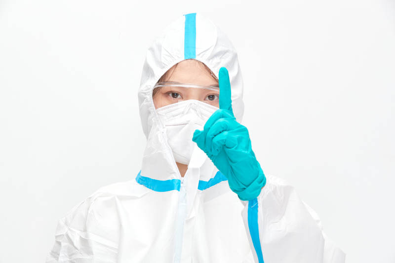 穿白色防护服佩戴护目镜口罩的女性医疗人员图片