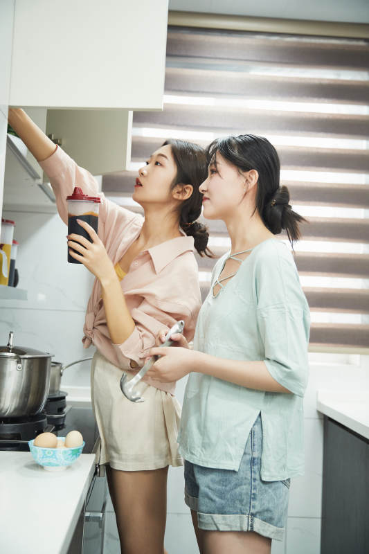 在厨房烹饪美食的亚洲闺蜜少女图片