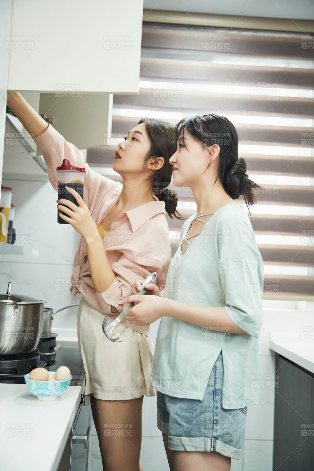 在厨房烹饪美食的亚洲闺蜜少女图片