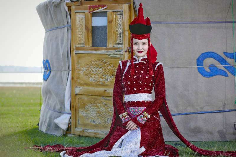 草原上穿着蒙古族传统服饰的亚洲年轻美少女图片