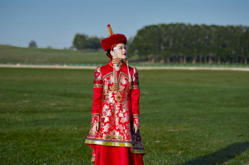 草原上穿着蒙古族传统服饰的亚洲年轻美少女图片