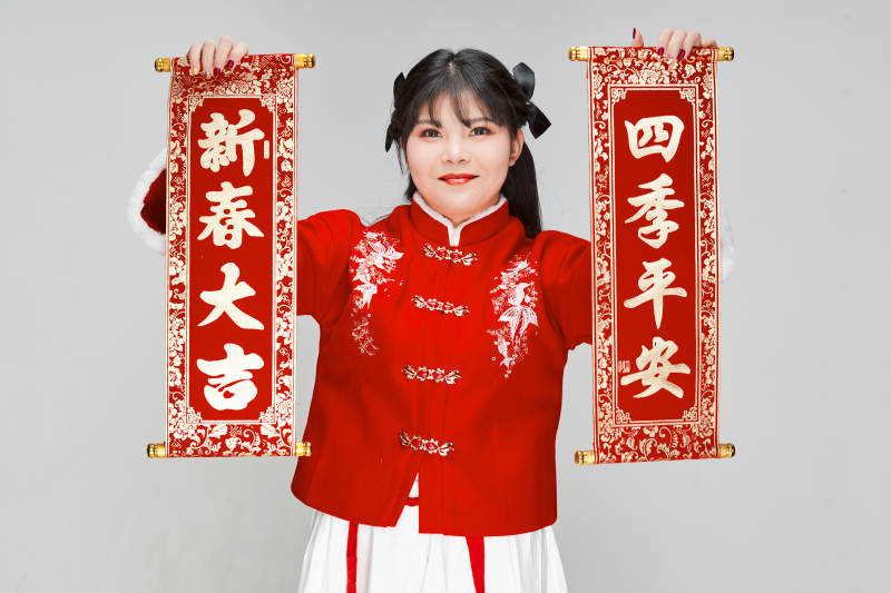手持春联身穿喜庆汉服的可爱少女图片