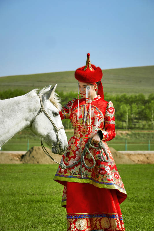 草原上穿着蒙古族传统服饰的亚洲年轻美少女图片